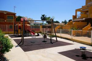 un parque infantil con columpio en un edificio en Apartamento Belvedere - Deniasol, en Denia