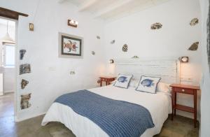 a white bedroom with a bed and two tables at Casa el Alto - Picon in Punta de Mujeres