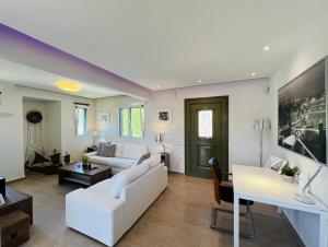 a living room with a white couch and a table at Lefkada Beach Villa in Lefkada