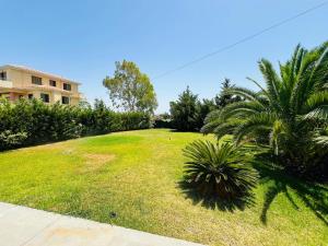 a large yard with palm trees and a house at Lefkada Beach Villa in Lefkada