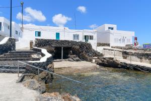 a building with stairs and water in front of it at Casa el Alto - Picon in Punta de Mujeres