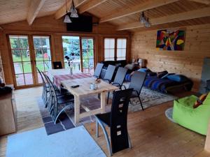 ein Esszimmer mit Tisch, Stühlen und Sofa in der Unterkunft Ramus Ūkis in Jakiškiai