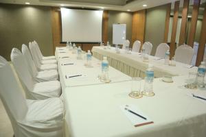 een rij tafels met witte stoelen en waterflesjes bij De Sovrani in kolkata +15 foto's