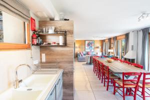 a kitchen and dining room with a table and red chairs at Chalet Galbert, Vaujany in Vaujany +28 photos
