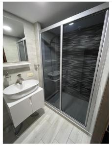 a bathroom with a glass shower and a sink at Crown Hotel in Kutaisi