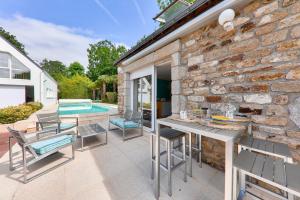 a patio with a table and chairs and a pool at Maison pour 8 avec piscine 500m de la plage in Arradon
