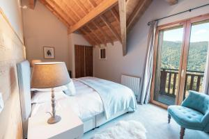 a bedroom with a bed and a chair and a window at Chalet Galbert, Vaujany in Vaujany