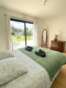 a bedroom with a large bed with two pillows on it at Grande Maison - Proche plages - Combrit Ste Marine in Combrit