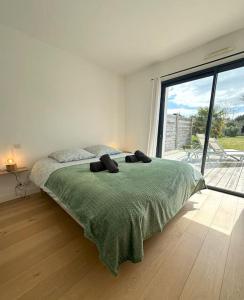 a bedroom with a bed and a large window at Grande Maison - Proche plages - Combrit Ste Marine in Combrit