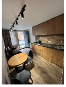 a kitchen with a wooden table and chairs in a room at Crown Hotel in Kutaisi