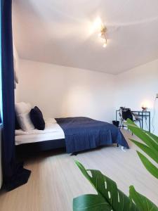 a bedroom with a bed with a blue blanket at Central Large Double Room With Free Parking in Hjørring