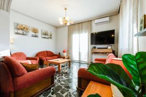 a living room with red furniture and a tv at Chania Dream House in Chania
