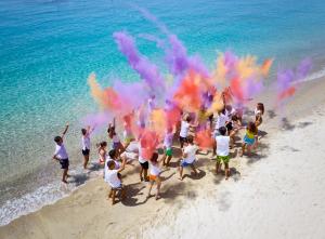 a group of children playing on the beach with colored smoke at Calaserena Resort in Geremèas +30 photos