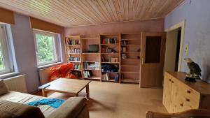 RehauにあるAltes Zollhaus im Waldのリビングルーム(ソファ、テーブル、本棚付)