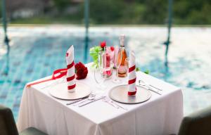 a table with a bottle of wine and glasses on it at The Marina Phuket Hotel in Patong Beach