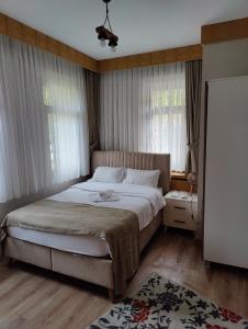 a bedroom with a large bed and a window at Aydere Apart Hotel in Ayder Yaylasi