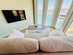 a living room with a couch and large windows at Holibai, Miradoiro Apt En Zona De Lujo, Baiona in Baiona