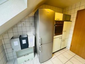 a stainless steel refrigerator in a small kitchen at Ferienunterkunft Monteurwohnung Hagenbach in Hagenbach