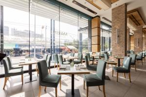 a restaurant with tables and chairs and large windows at The Marina Phuket Hotel in Patong Beach