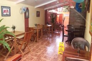 a restaurant with wooden tables and chairs in a room at Citadel Bed and Breakfast in Puerto Princesa City