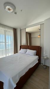 una camera da letto con un letto grande con una grande finestra di Jadran Dream2 a Rafailovici