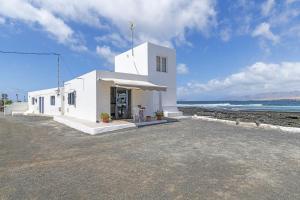 a white church on the beach with the ocean at La Casita Del Mar in Caleta de Caballo