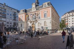 un grand bâtiment avec une foule de gens devant lui dans l'établissement Studio Granier sud, à Chambéry