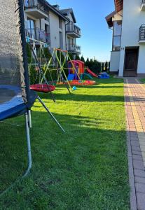 a yard with a playground in the grass at Komfort i spokój blisko natury - Apartamenty i pokoje ARKO in Ostrowo