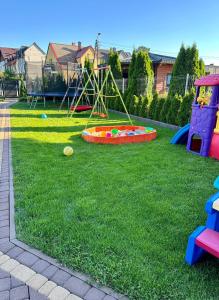 a yard with a playground with a swing at Komfort i spokój blisko natury - Apartamenty i pokoje ARKO in Ostrowo