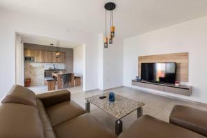 a living room with a couch and a table and a tv at Villa La Domazet in Podstrana