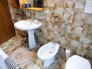 a bathroom with a sink and a toilet at Villetta Giulietta-casa con giardino e parcheggio in Grado +64 photos