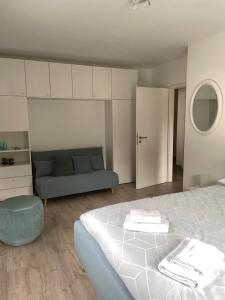a bedroom with a bed and a blue couch at Cedrien Appartement met terras in La-Roche-en-Ardenne