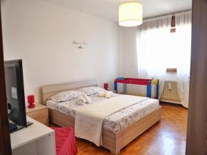 a bedroom with a bed and a flat screen tv at Villetta Giulietta-casa con giardino e parcheggio in Grado