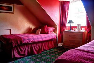 a red bedroom with two beds and a window at Atticus Central Guest House in Aberdeen