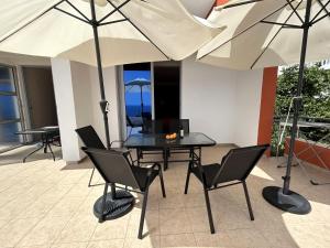 a patio with a table and chairs and umbrellas at Apartments Olga in Ulcinj
