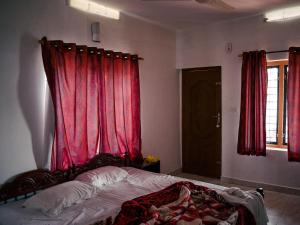 una camera da letto con letto e tende rosse di Depak hotel a Janakpur