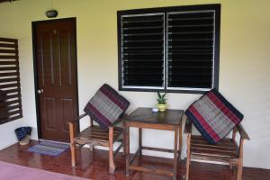 a room with a table and two chairs and a window at M&M Guesthouse in Ko Chang