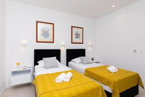 two beds in a room with yellow sheets at Beautifull Villa Adriatis with pool in Brač in Sutivan +43 photos