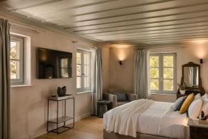 una camera da letto con un letto e due finestre di Hydroussa Hotel Hydra a Hydra