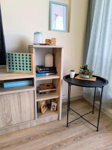 a table next to a book shelf with a table at sea view hygge - Quiet residential apartment in Kavarna