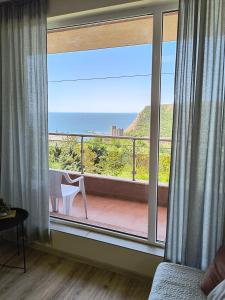 a bedroom with a large window with a view of the ocean at sea view hygge - Quiet residential apartment in Kavarna
