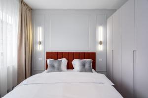 a bedroom with a large white bed with two pillows at Dreamy City Center in Bucharest
