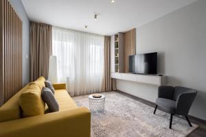 a living room with a yellow couch and a television at Dreamy City Center in Bucharest
