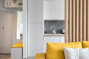 a living room with a yellow couch and a kitchen at Dreamy City Center in Bucharest