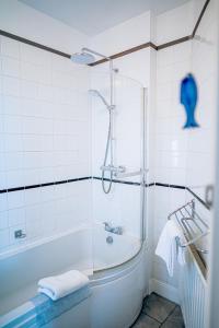 a white bathroom with a tub and a shower at Marazion Beach Town House with Private Parking in Marazion +40 photos