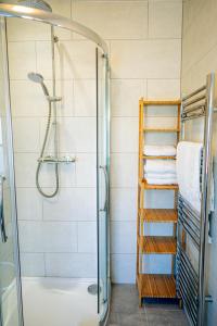 a shower in a bathroom with a glass shower backdoor at Marazion Beach Town House with Private Parking in Marazion