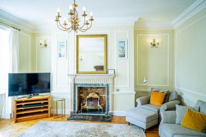a living room with a fireplace and a television at Marazion Beach Town House with Private Parking in Marazion