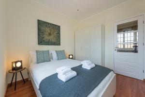 a bedroom with a bed with towels on it at GuestReady - Cosy getaway in Porto in Bandeira
