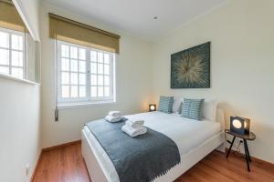 a bedroom with a large white bed with blue pillows at GuestReady - Cosy getaway in Porto in Bandeira