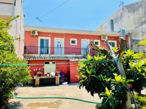 a red house with a hose in front of it at Ocean Eyes in Ipsos